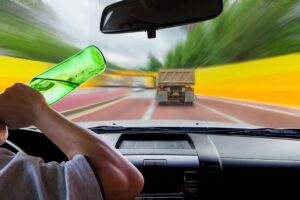 Woman drinking while driving.